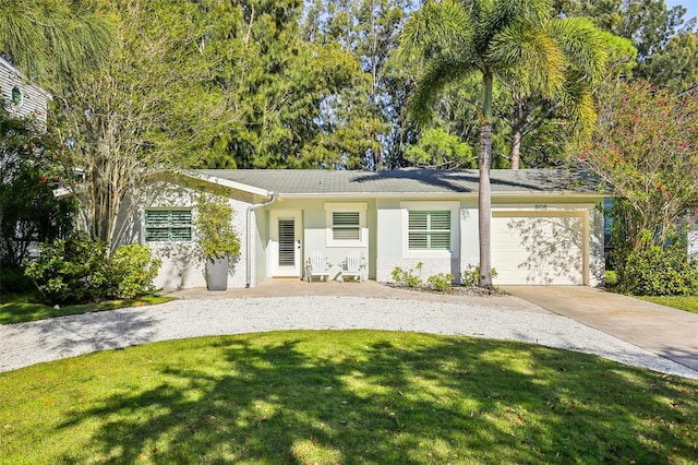 1908 Sutherland Dr W, Palm Harbor, FL 34683 - view of front facade with driveway, an attached garage, stucco siding, and a front yard