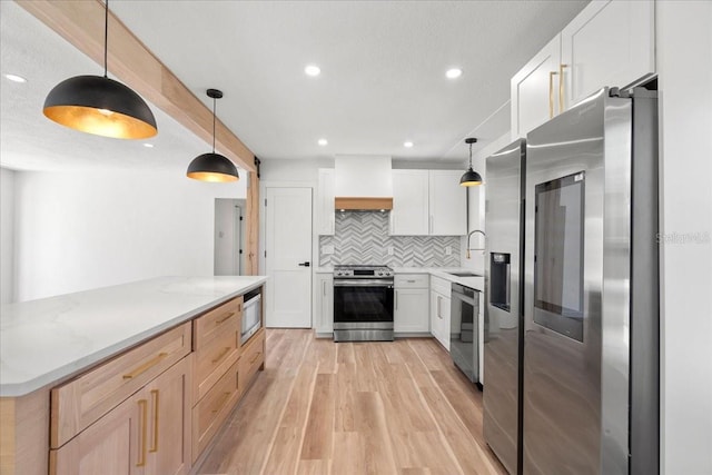 6531 2nd Ave N, Saint Petersburg, FL 33710 - kitchen with light wood-type flooring, custom exhaust hood, appliances with stainless steel finishes, a sink, and decorative backsplash
