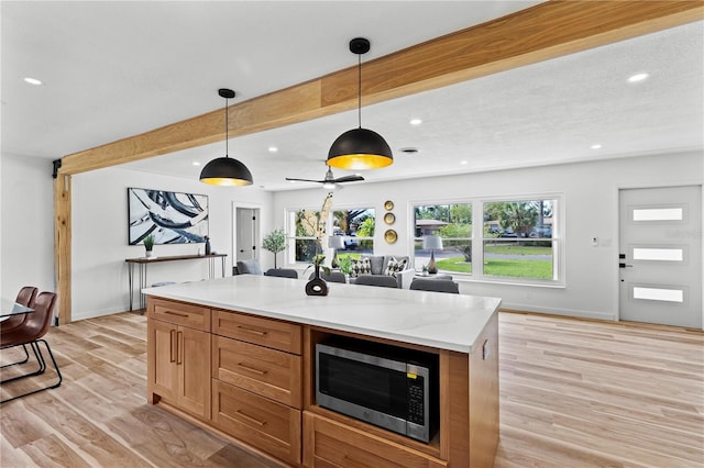 6531 2nd Ave N, Saint Petersburg, FL 33710 - kitchen featuring recessed lighting, beam ceiling, stainless steel microwave, and light wood finished floors
