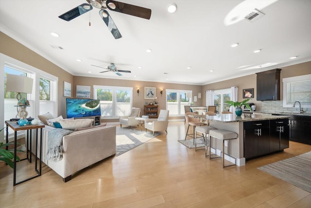 living room featuring ornamental molding and a ceiling fan