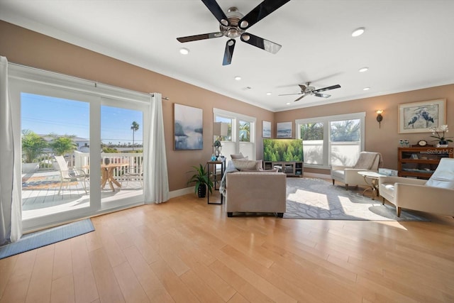 living area with recessed lighting, ceiling fan, ornamental molding, and light wood-type flooring