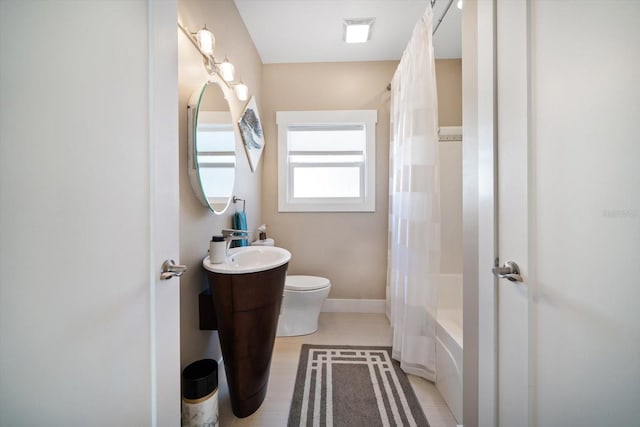bathroom with toilet, baseboards, shower / tub combo, and vanity
