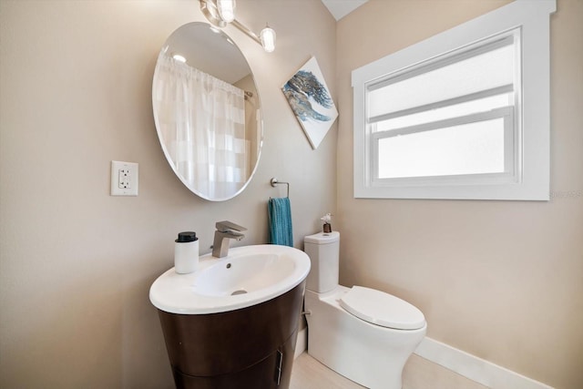 full bath featuring a sink, baseboards, toilet, and curtained shower