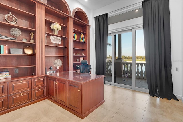 6113 Pasadena Point Blvd, Gulfport, FL 33707 - home office with light tile patterned floors, built in desk, and built in shelves