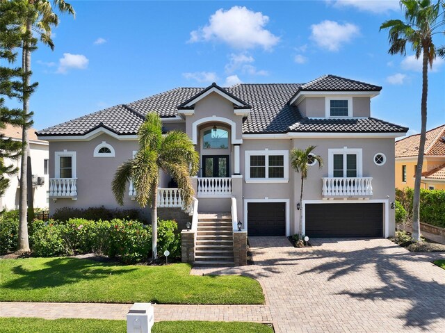 6113 Pasadena Point Blvd, Gulfport, FL 33707 - mediterranean / spanish house with stucco siding, an attached garage, stairway, decorative driveway, and french doors