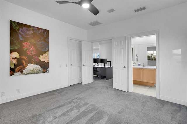 6113 Pasadena Point Blvd, Gulfport, FL 33707 - unfurnished bedroom featuring light colored carpet, a desk, ensuite bathroom, and a ceiling fan
