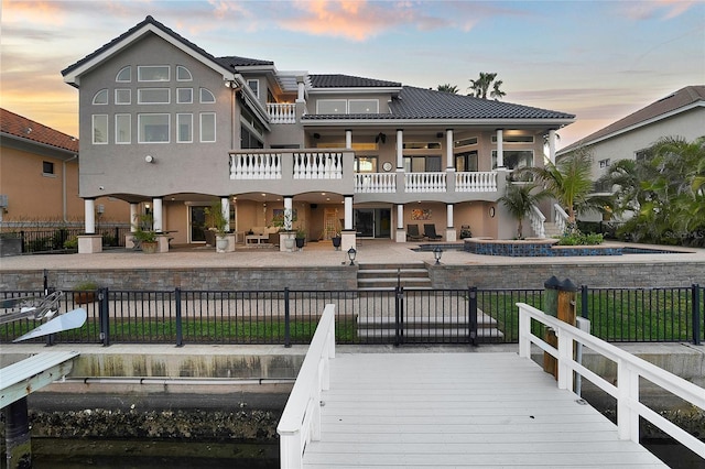 6113 Pasadena Point Blvd, Gulfport, FL 33707 - back of property at dusk featuring a patio area, a fenced backyard, and a balcony