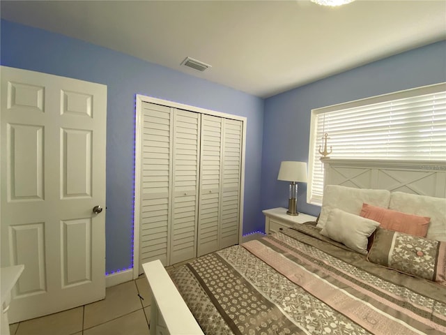 tiled bedroom with visible vents and a closet