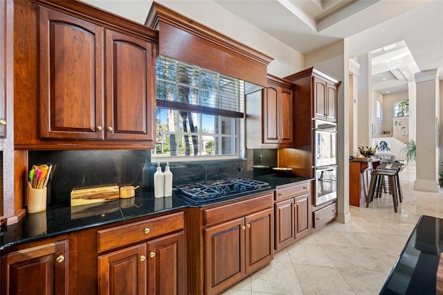 19005 Cour Ests, Lutz, FL 33558 - kitchen featuring black gas stovetop, backsplash, dark stone counters, light tile patterned floors, and stainless steel double oven
