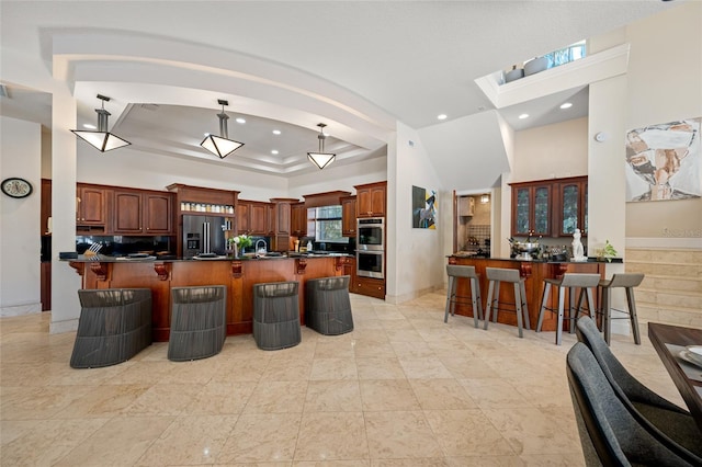 19005 Cour Ests, Lutz, FL 33558 - kitchen with a breakfast bar area, stainless steel appliances, dark countertops, recessed lighting, and a tray ceiling