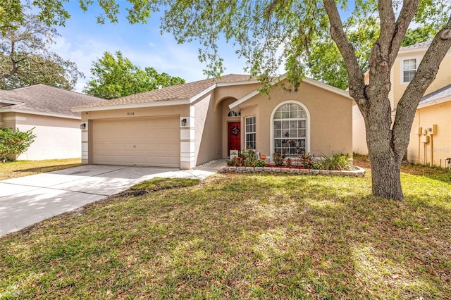 view of front of home with stucco siding, a front lawn, a garage, and driveway