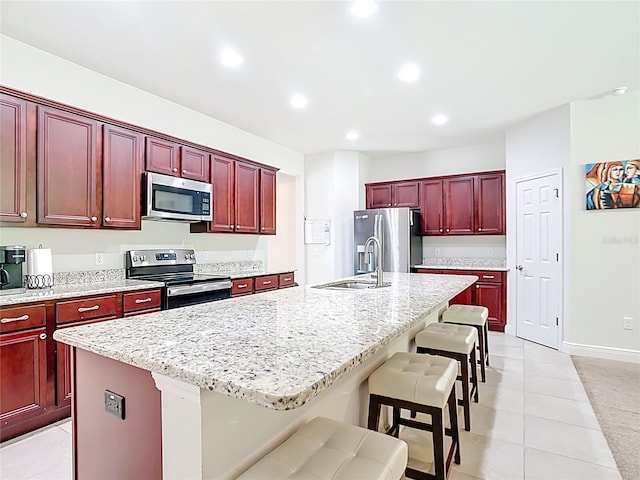 5235 SE 91st St, Ocala, FL 34480 - kitchen featuring a kitchen island with sink, a sink, appliances with stainless steel finishes, and reddish brown cabinets