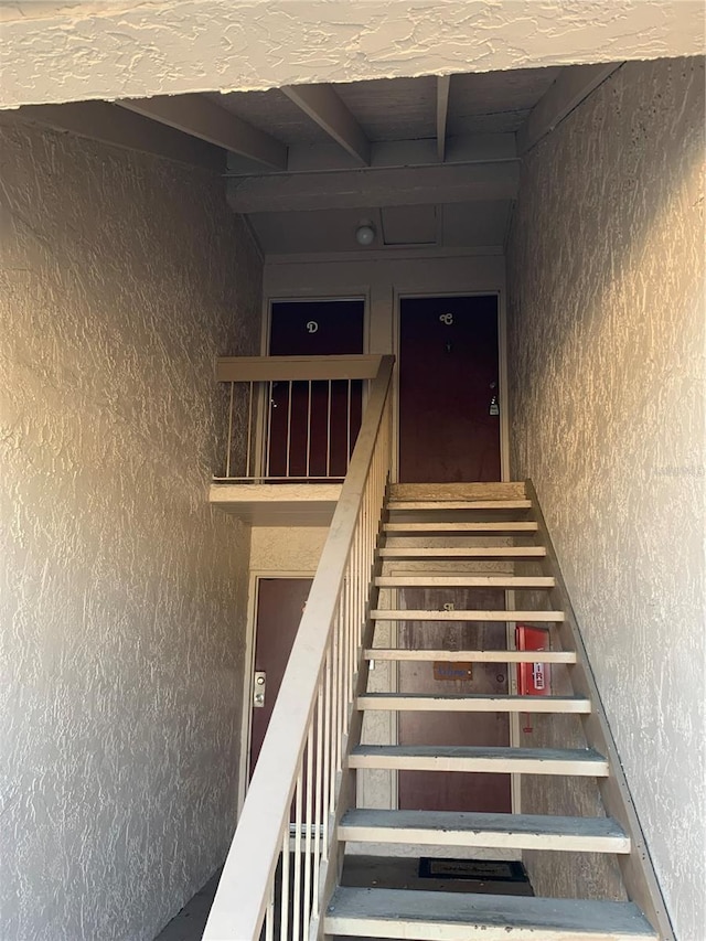 7526 Needle Leaf Pl Unit 30, Tampa, FL 33617 - stairs with beamed ceiling and a textured wall