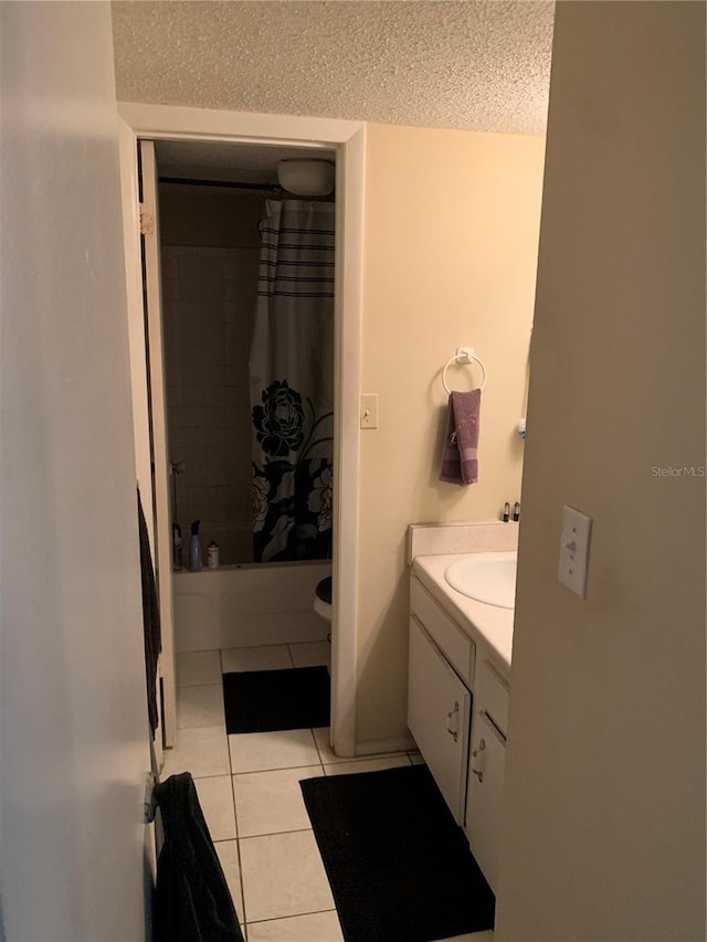 7526 Needle Leaf Pl Unit 30, Tampa, FL 33617 - bathroom with shower / bathtub combination with curtain, toilet, a textured ceiling, tile patterned flooring, and vanity