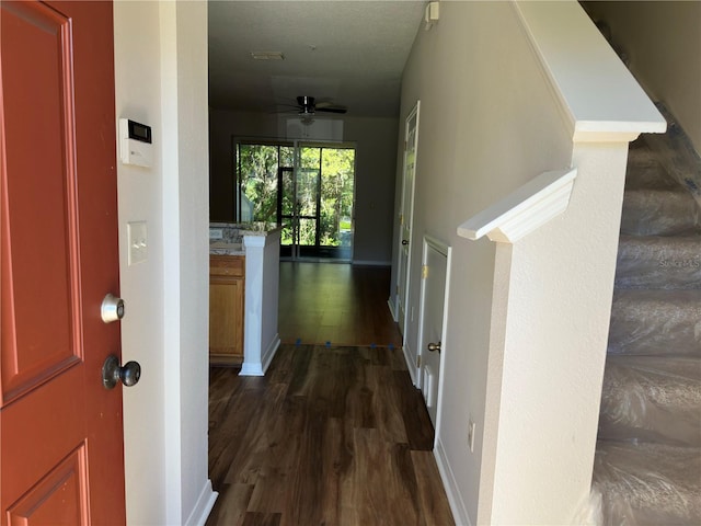 corridor featuring baseboards and dark wood-style flooring