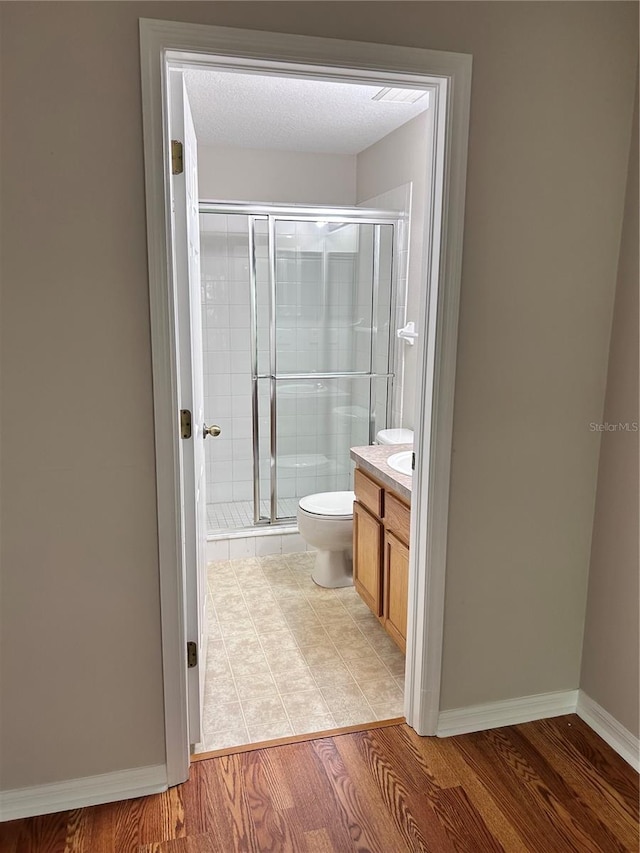 2061 Fiesta Ridge Ct, Tampa, FL 33604 - full bath featuring toilet, baseboards, wood finished floors, a shower stall, and vanity