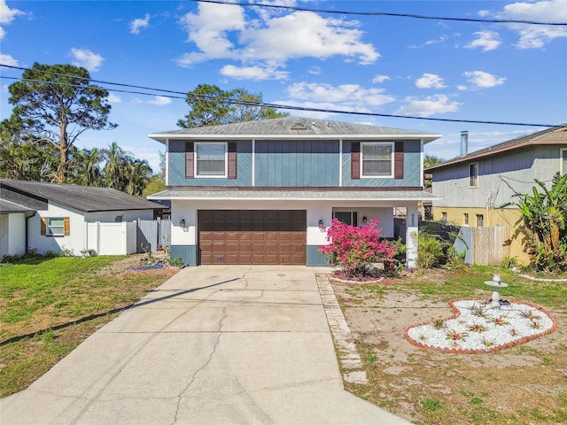 view of front of property with driveway, a front lawn, a garage, and fence