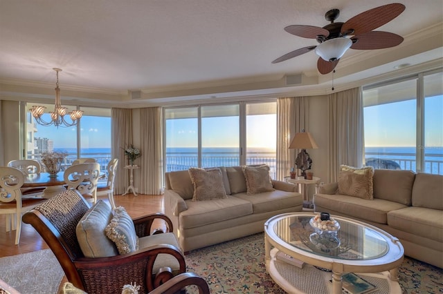 living area featuring a water view, visible vents, ceiling fan with notable chandelier, and a healthy amount of sunlight