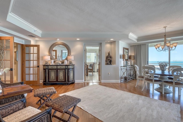 living area with a notable chandelier, ornamental molding, visible vents, and plenty of natural light