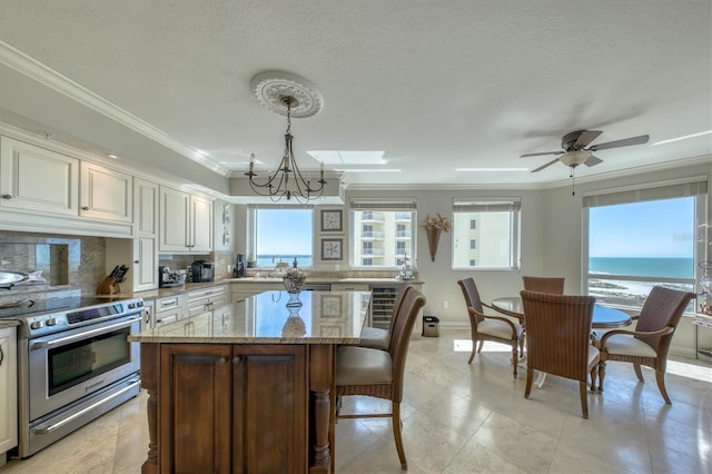 kitchen featuring tasteful backsplash, ornamental molding, a center island, electric range, and light stone countertops