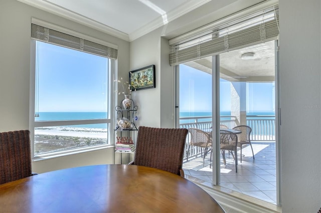 dining area featuring a water view and crown molding