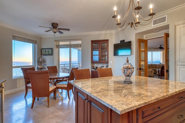 kitchen featuring brown cabinets, ceiling fan with notable chandelier, crown molding, and visible vents