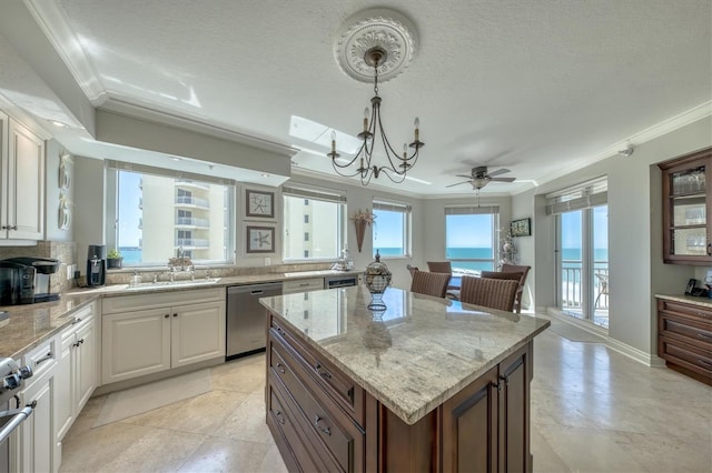 kitchen with stainless steel dishwasher, a ceiling fan, ornamental molding, and light stone counters