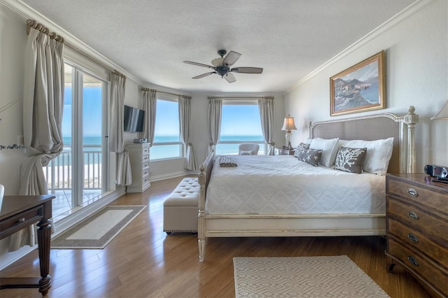 bedroom featuring access to outside, ceiling fan, a textured ceiling, ornamental molding, and wood finished floors