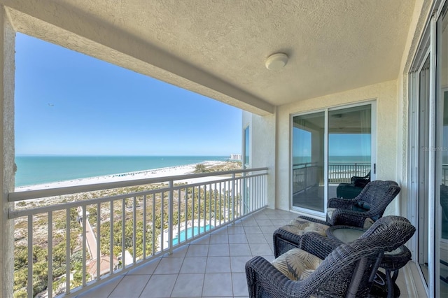 balcony with a water view and a beach view