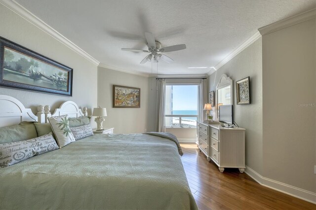 bedroom featuring a ceiling fan, dark wood-style flooring, baseboards, and ornamental molding