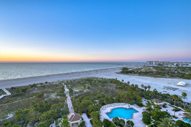 birds eye view of property with a water view and a beach view