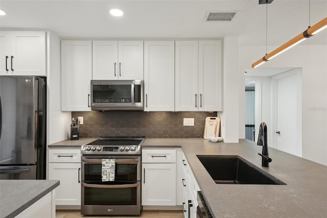 6277 Bahia Del Mar Blvd Unit 210, Saint Petersburg, FL 33715 - kitchen with appliances with stainless steel finishes, a sink, decorative backsplash, white cabinets, and recessed lighting