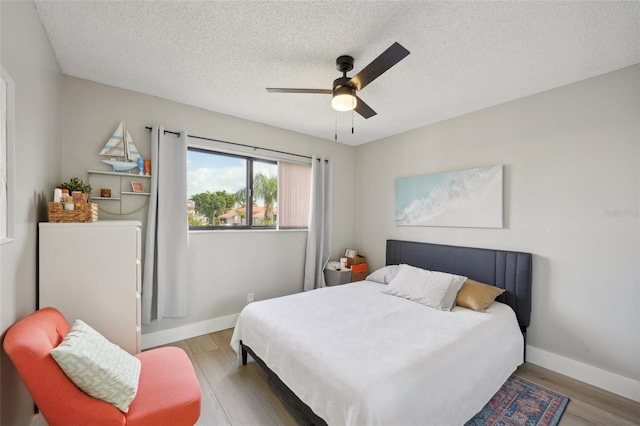 6277 Bahia Del Mar Blvd Unit 210, Saint Petersburg, FL 33715 - bedroom featuring wood finished floors, a textured ceiling, baseboards, and a ceiling fan