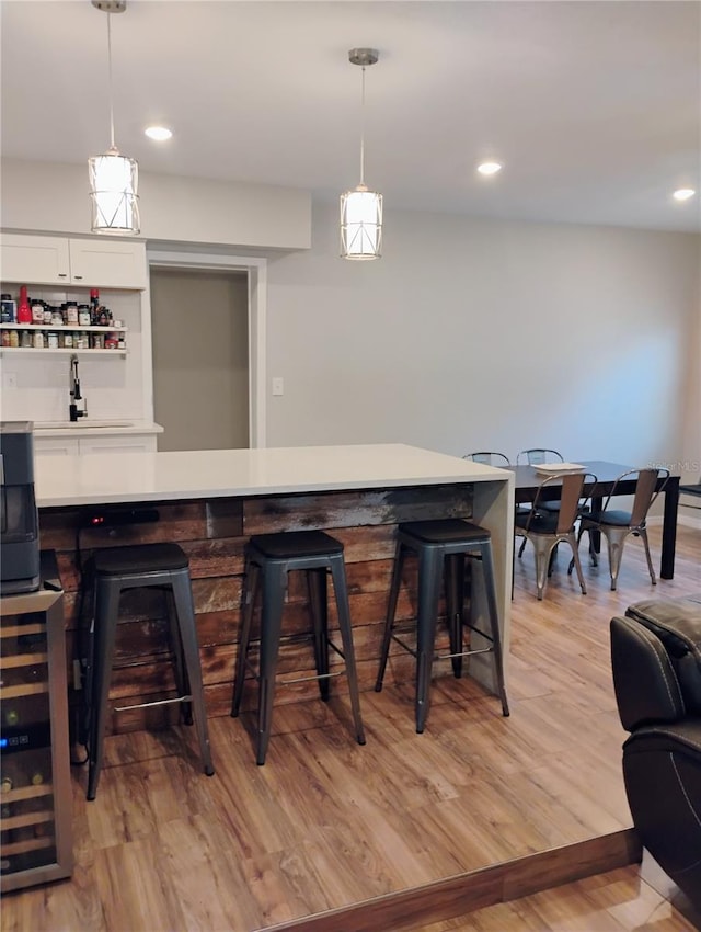 11233 51st Ave N, Saint Petersburg, FL 33708 - bar with pendant lighting, light wood-type flooring, a dry bar, and wine cooler
