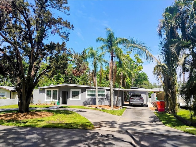 11233 51st Ave N, Saint Petersburg, FL 33708 - view of front of property with concrete driveway, stucco siding, an attached carport, and a front lawn