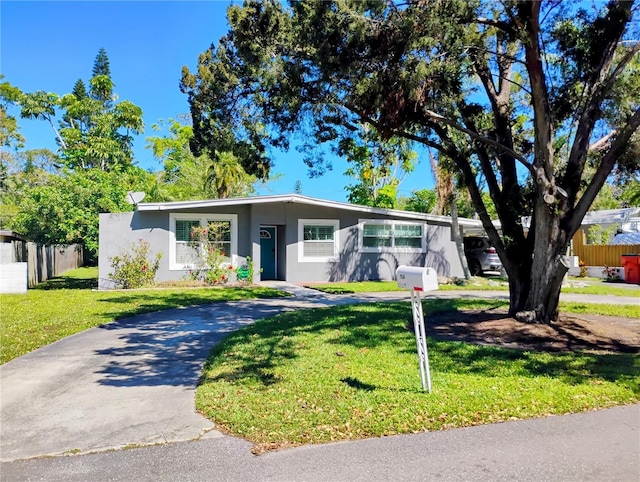 11233 51st Ave N, Saint Petersburg, FL 33708 - mid-century inspired home featuring a front lawn, fence, driveway, and stucco siding