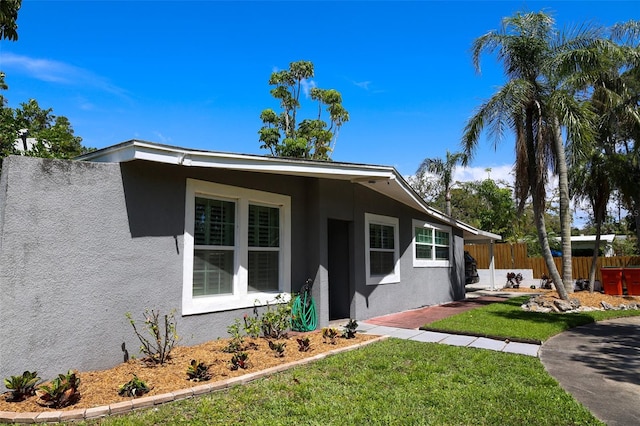 11233 51st Ave N, Saint Petersburg, FL 33708 - view of front facade with stucco siding, fence, and a front lawn