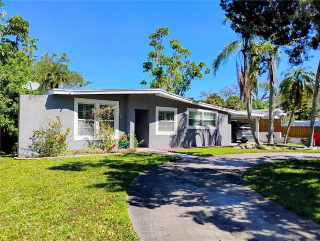 11233 51st Ave N, Saint Petersburg, FL 33708 - mid-century inspired home with a front yard, stucco siding, fence, and curved driveway