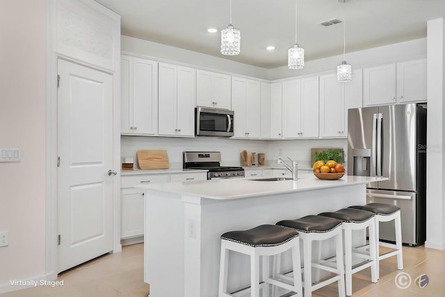 14180 Samoa Hill Ct, Riverview, FL 33569 - kitchen featuring stainless steel appliances, a sink, a kitchen bar, white cabinetry, and recessed lighting