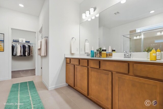 14180 Samoa Hill Ct, Riverview, FL 33569 - bathroom featuring a shower stall, double vanity, a walk in closet, tile patterned floors, and baseboards