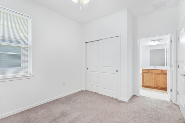 14180 Samoa Hill Ct, Riverview, FL 33569 - unfurnished bedroom with light carpet, a closet, baseboards, ensuite bath, and a sink