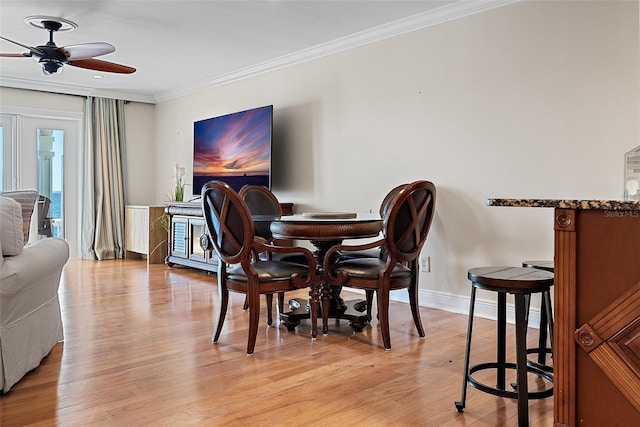 dining space with ceiling fan, light wood-style flooring, baseboards, and ornamental molding
