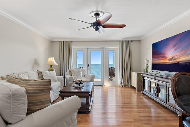 living area with wood finished floors, ceiling fan, and ornamental molding