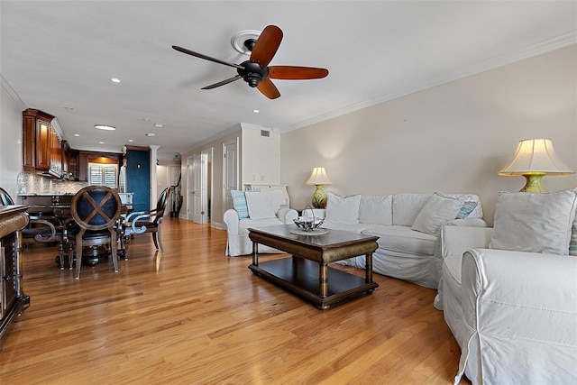 living area with recessed lighting, light wood-style floors, ceiling fan, and crown molding