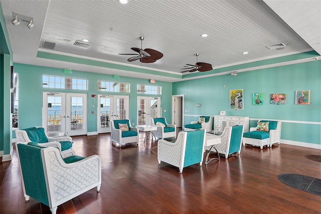 living area featuring wood finished floors, visible vents, ceiling fan, french doors, and a raised ceiling