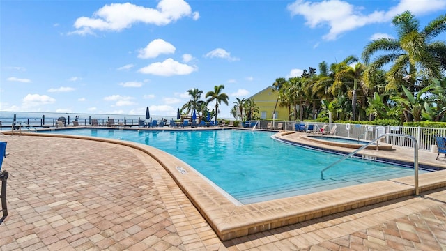 community pool featuring a community hot tub, a patio, and fence