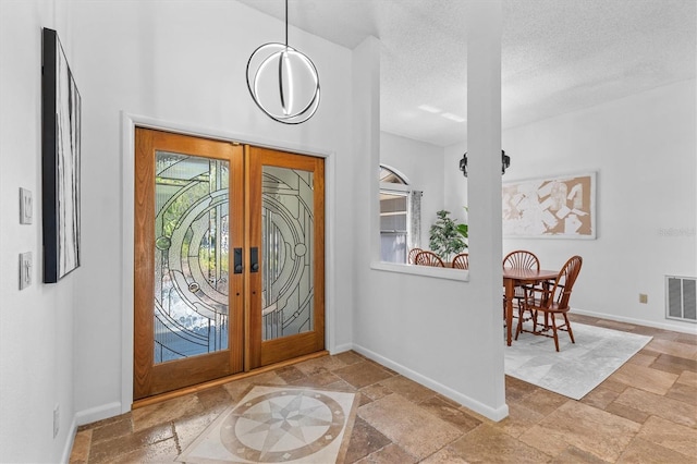 entrance foyer featuring visible vents, plenty of natural light, and stone tile floors