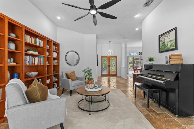 living area featuring stone tile floors, a ceiling fan, visible vents, recessed lighting, and french doors
