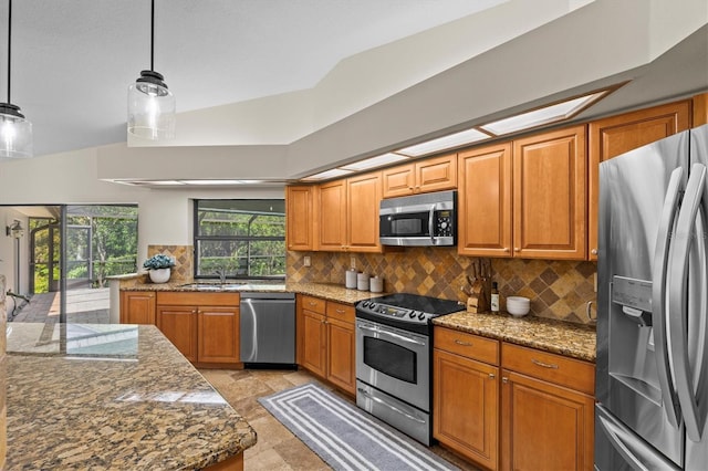 kitchen featuring backsplash, brown cabinets, appliances with stainless steel finishes, and a sink