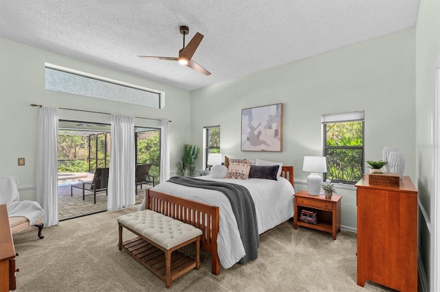 bedroom featuring light colored carpet, a textured ceiling, a ceiling fan, and access to outside